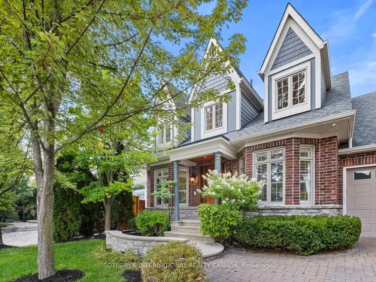 Red-brick detached home with grey dormers, a landscaped front garden, paver driveway and attached garage at 8 Harper Hill Road, Markham, Ontario
